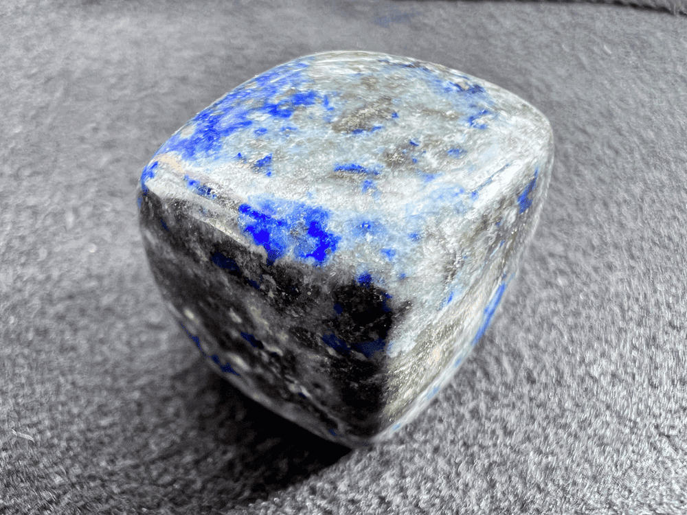 cube bleu de lapis lazuli sur fond neutre pour illustrer une pierre bleue