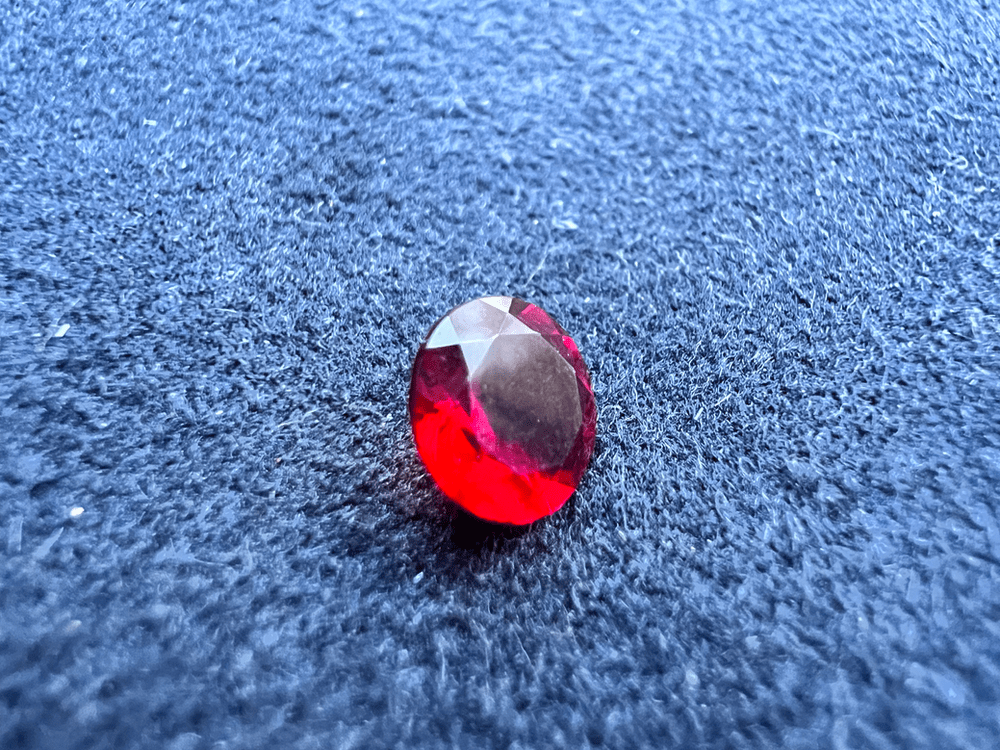 pierre de verre rouge en pierre taillée sur fond neutre pour illustrer les imitations du grenat almandin