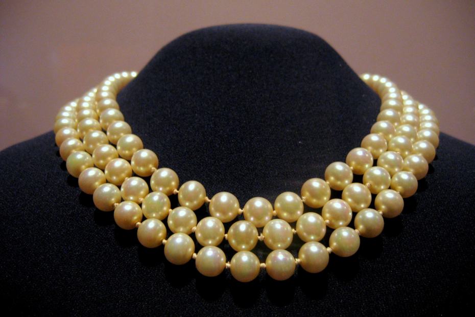 collier de perles de jackie kennedy sur mannequin en tissu noir pour illustrer le collier de perles à l'ère moderne