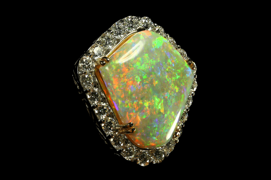 pendentif faits d'opale blanche avec des feux prononcés multicolores, diamants blancs et or blanc sur fond noir pour illustrer un pendentif en opal