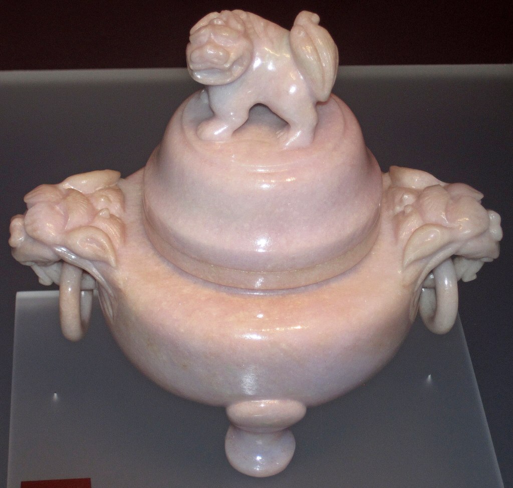 bruleur d'encens chinois, datant de la période Qing (1644-1911) qui ressemble à un pot avec un chien chinois de chaque coté et un sur le couvercle au dessus. les chiens chinois de protection sur les côtés ortent un anneau dans leur bouche. Le pot est en jade jadéite rose pastel  