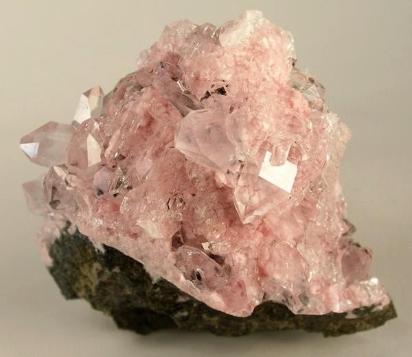 morceau de roche recouvert de cristaux formés et microcristaux de rhodochrosite rose pastel 