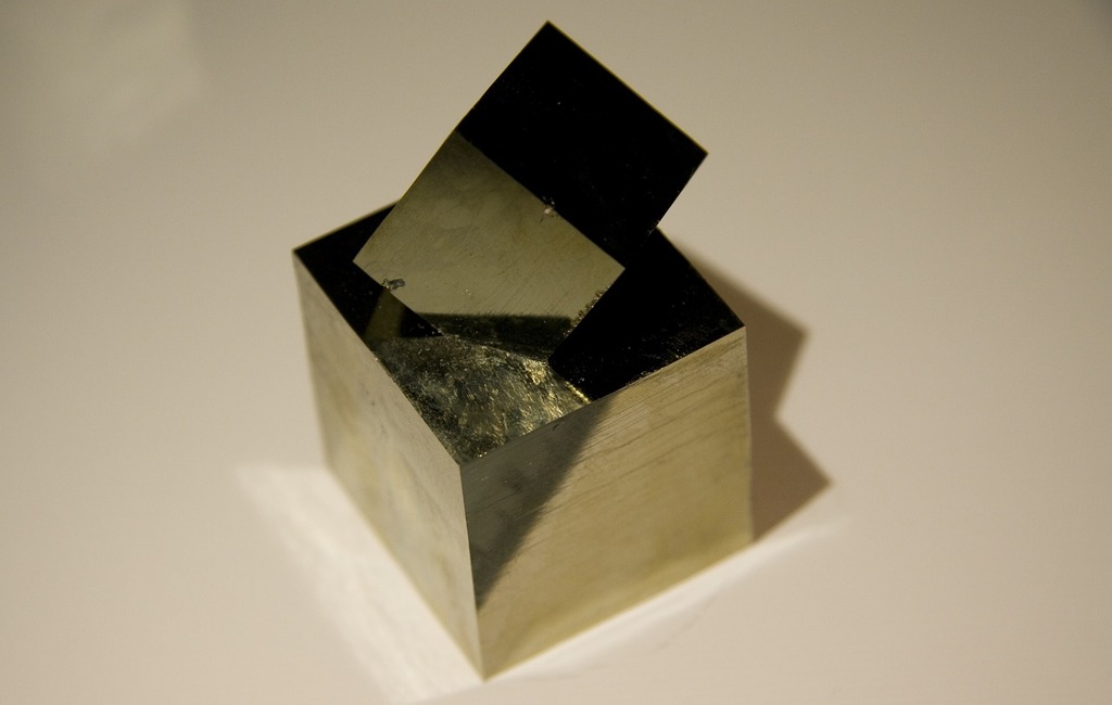 Pyrite naturelles, potentiellement polie qui montre un cube parfait couleur or et metallique avec une duexième cube imbriquée sur le dessus